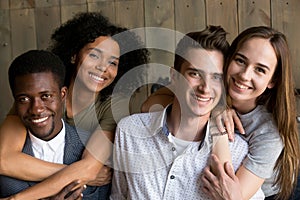 Two african and caucasian couples embracing looking at camera, p