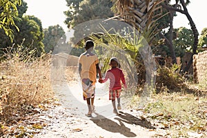 Two African Children Walk Down Natural Road in African Village