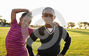 Two African elementary schoolgirls pose to camera in a field