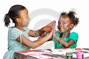 Two African girls having fun painting at desk