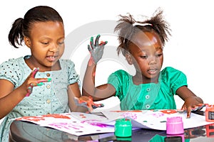 Two African girls having fun at table painting
