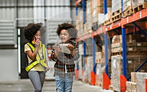 Two African little boy, girl kid playing together with happiness in warehouse or factory, using walkie talkie, pretend to be