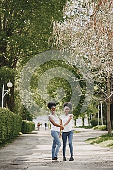 Twin sisters holding hands and walking in a park photo