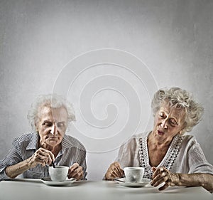 Two aged women drinking tea