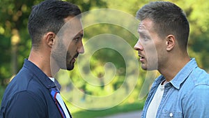 Two aggressive males arguing outdoor, claims and disagreement, conflict close-up