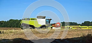 Two agricultural machines operate in the field, grain harvesting machines operate in the field, agricultural land