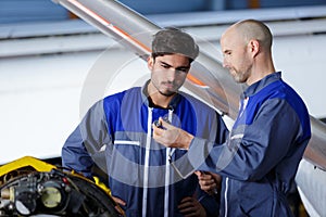 two air mechanics engineers with aircraft in background