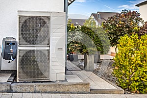 Two air source heat pumps installed outside of modern family house, green renewable energy concept of heat pump