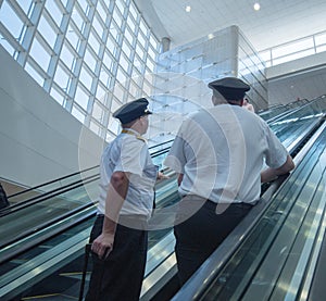 Airline pilots on the way to plane inside airport