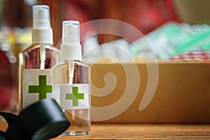 Two alcohol antiseptics with green cross logo on wooden table.