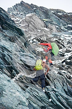 Two alpinists climbing rocky mountain.