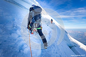 Two alpinists mountaineers climbing over ice crevasse