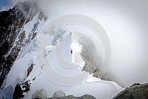 Two alpinists walking thin mountain ridge photo