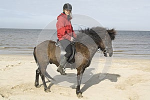 Two amazones on horseback on the beach