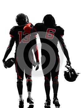 Two american football players walking rear view silhouette