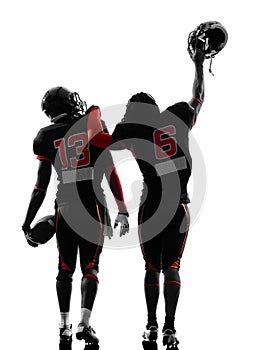 Two american football players walking rear view silhouette