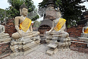 Two Ancient Buddha Images Clad In Saffron Robes