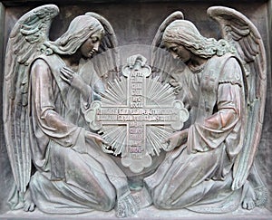 Two angels hold cross