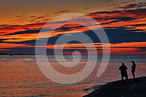 Two anglers on the Baltic Sea in the sunset