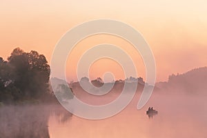 Two anglers on a boat enjoys fishing on a beautiful morning.