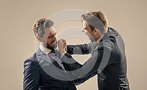 two angry businessmen punching in fight and arguing having struggle for leadership, confrontation.