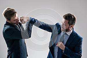 two angry businessmen punching in fight because of business competition, business knockout.