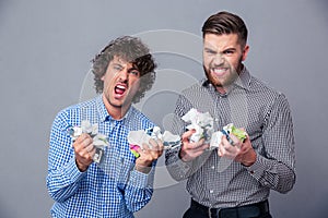 Two angry men with crumpled paper