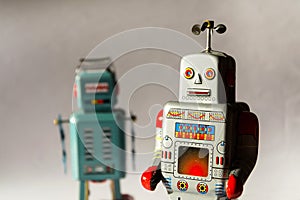 Two angry vintage tin toy robots, artificial intelligence, robotic drone delivery, machine learning concept