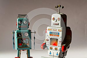 Two angry vintage tin toy robots, artificial intelligence, robotic drone delivery, machine learning concept