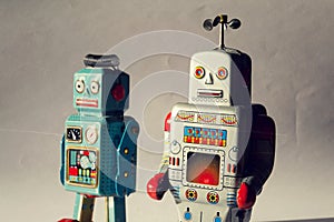 Two angry vintage tin toy robots, artificial intelligence, robotic drone delivery, machine learning concept
