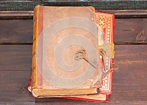 Two antique books on a wooden shelf with some old skeleton keys