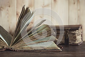 Two antique shabby books on light wooden background.