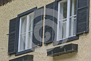 Two antique windows with open wooden shutters in Austria.