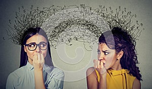 Two anxious women looking at each other exchanging with many thoughts