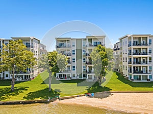 two apartment buildings on the edge of the water near a beach,  in Lakeport New Hampshire.