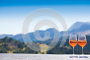 Two Aperol Spritz cocktails in ice cold glasses on the table of a cafe on the top of the mountain in Alta Badia