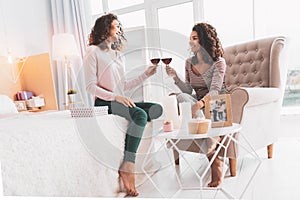 Two appealing women clanging their glasses with wine