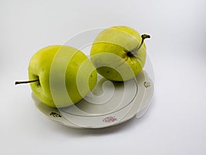 Two apples on a saucer.