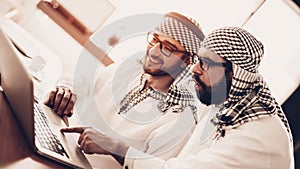 Two Arab businessmen looking on laptop together