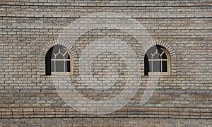 Two Arched Windows. Classic arched windows on red brick wall with curtains and blinds, city reflection in glass. apartment