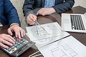 Two architect partners working at houme draw construction with laptop and tools at office photo