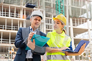 Two architects with laptop discussing construction plan