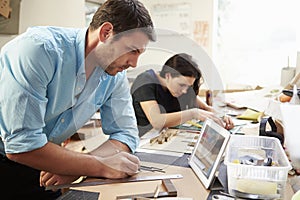 Two Architects Making Models In Office Using Digital Tablet