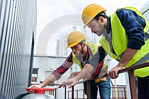 two architects in safety vests and hardhats working