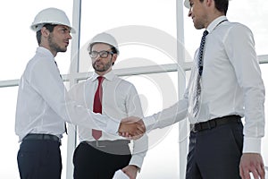 Two architects shaking hands after a meeting in office