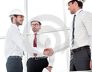 Two architects shaking hands after a meeting in office