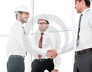 Two architects shaking hands after a meeting in office