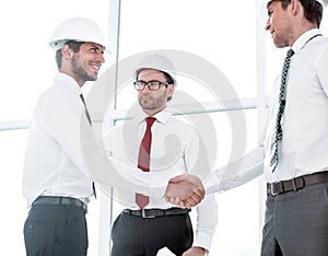Two architects shaking hands after a meeting in office