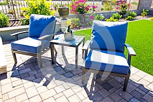 Two Arm Chairs With Blue Cushions & Small Table On Rear Patio Pavers