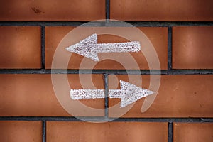 Two arrows pointing forward and backward drawn on bricks